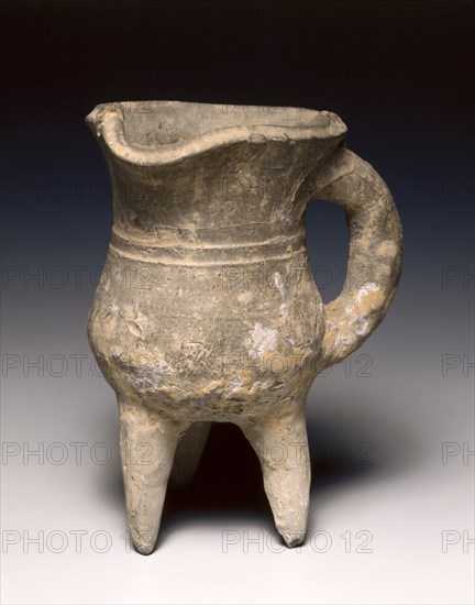 Wine Warmer (Jue), c. 1300-1023 BC. China, Shang dynasty (c.1600-c.1046 BC), Anyang phase (c.1250-1046 BC). Pottery, tripod vessel with loop handle and rudimentary bowstring decoration; diameter: 10.4 cm (4 1/8 in.); overall: 14.7 cm (5 13/16 in.).