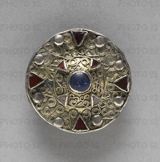 Filigree Disk Brooch with Central Boss, late 600s. Frankish (late Merovingian), 7th century. Gilt silver, copper alloy, glass, almandine; overall: 4.2 x 4.3 x 1.8 cm (1 5/8 x 1 11/16 x 11/16 in.)