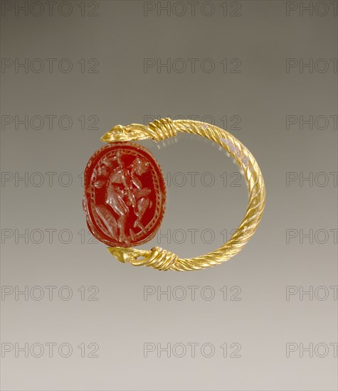 Gem Engraved with a Warrior Putting on Leg Armor; Etruria; 4th century B.C; Carnelian and gold; 0.8 × 1.4 × 1.1 cm