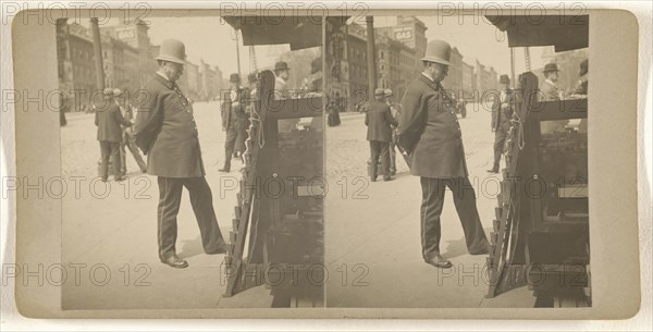 Policeman on Albany, N.Y. street reading newspapers on rack; Julius M. Wendt, American, active 1900s - 1910s, 1900s; Gelatin