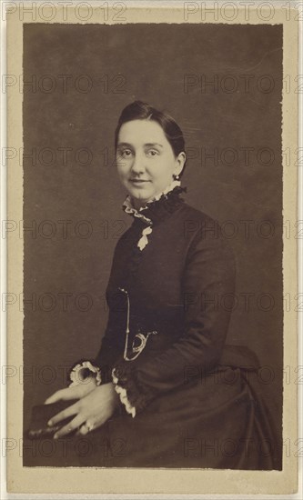 woman wearing a dark dress, holding a book, seated; 1865 - 1870; Albumen silver print