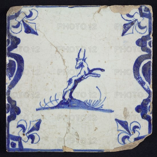 Animal tile, jumping buck to the right on ground between balusters, in blue on white, corner pattern french lily, wall tile