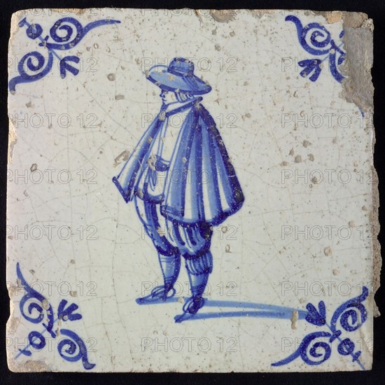 Figure tile, blue with nobleman with wide cape and big hat, corner pattern ox's head, wall tile tile sculpture ceramic