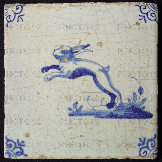 Animal tile, jumping hare to the left on ground, in blue on white, corner motif oxen head, wall tile tile sculpture ceramic