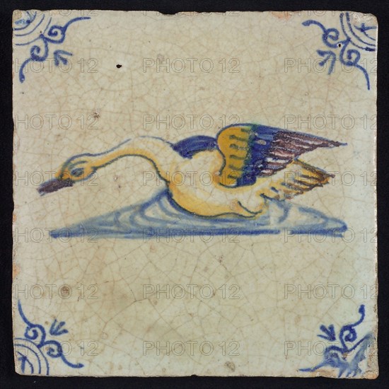 Animal tile, bird in water to the left in orange, purple and blue on white, corner motif ox's head, wall tile tile sculpture