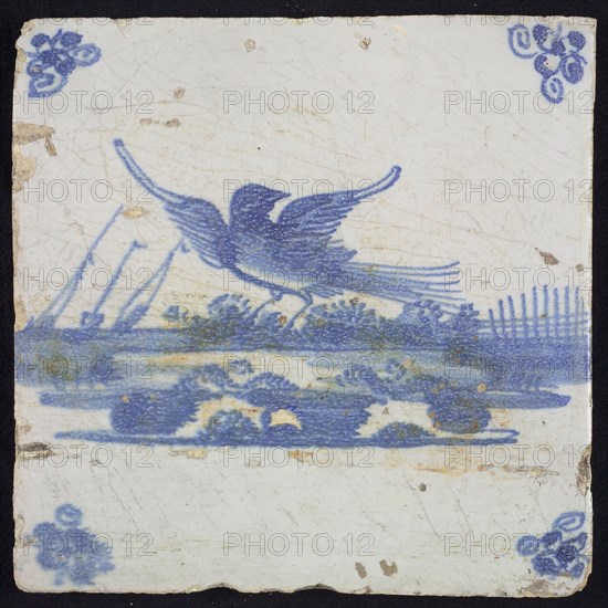 Animal tile, flying bird to the left above running water, in the background vegetation and ships in blue on white, corner