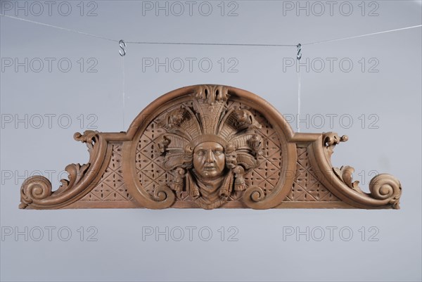 Carved and painted wooden standing ornament with head surrounded by curly leaves in the middle, ornament wood carving sculpture