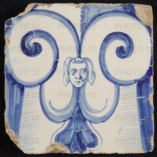 Tile of chimney pilaster, blue on white, stylized curly ornament between which maskon, chimney pilaster tile pilaster footage