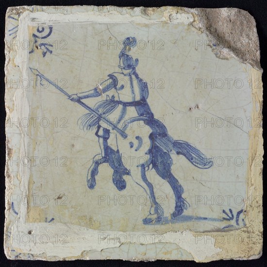 White tile with blue horseman with spear, seen from behind; corner pattern ox head, wall tile tile sculpture ceramic earthenware