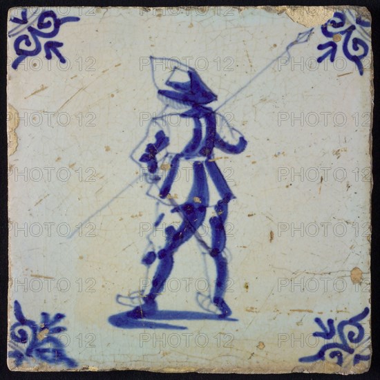 White tile with blue warrior with spear, seen from behind; corner pattern ox head, wall tile tile sculpture ceramic earthenware