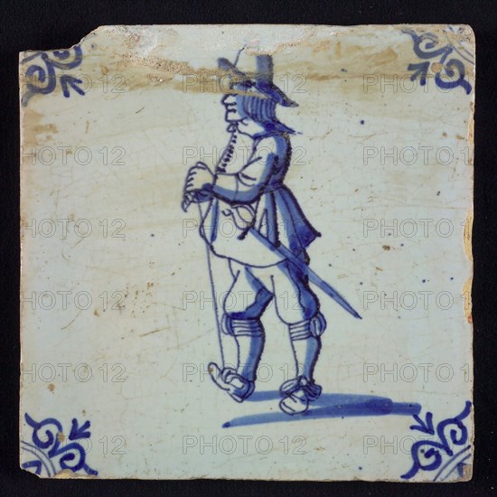 White tile with blue warrior with sword, stick and hat; corner pattern ox head, wall tile tile sculpture ceramic earthenware