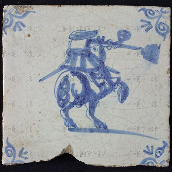 White tile with blue rider with rifle with smoke; corner pattern ox head, wall tile tile sculpture ceramic earthenware glaze