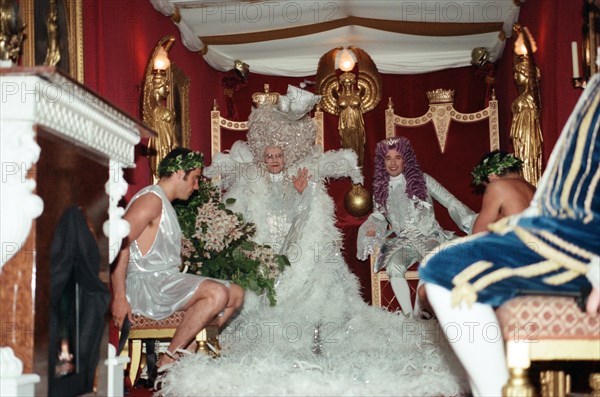 Elton John and David Furnish sitting on thrones in the back of a van which will take them to Elton's 50th birthday party at Hammersmith Palais. 6th April 1997.