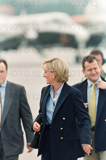 HRH, The Princess of Wales, Princess  Diana,  on her arrival at Sarajevo airport Friday, 8th August 1997  at the start of her two-day tour to publicise the international problem of land mines.

In the background, to the right in the yellow tie, i her butler, Paul Burrell.

Picture taken 8th August 1997