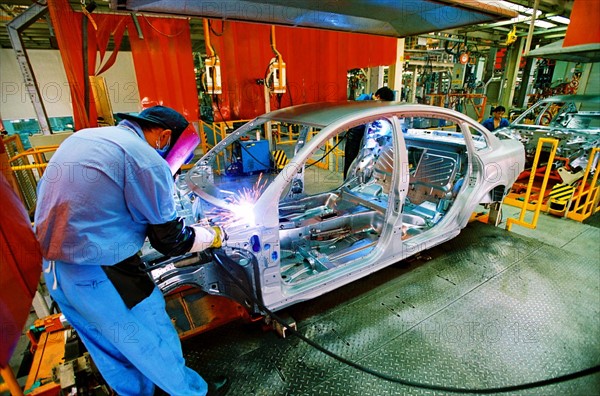 A worker welds in the workshop of Shanghai Volkswagen Automotive Company,Shanghai,China