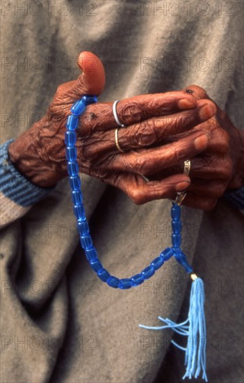 A woman outside a mosque in Pakistan saying the rosary (Tasbih)