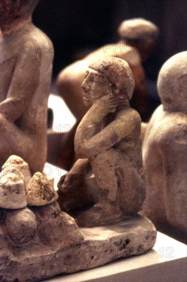 Man kneeling before loaves of bread