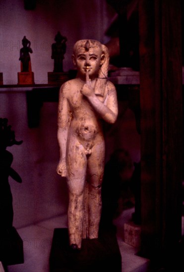 Representation of the royal child, wearing the uraeus and braided lock, with the index finger in front of the mouth