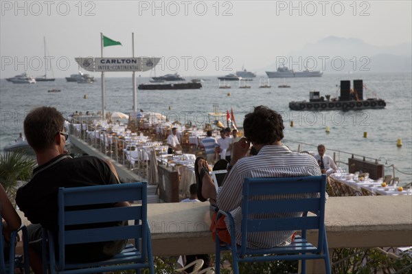 CoteAzur020 Cannes, la Croisette, les plages et la baie, yachts, plage de l'hötel Carlton, deux hommes assis face à la baie