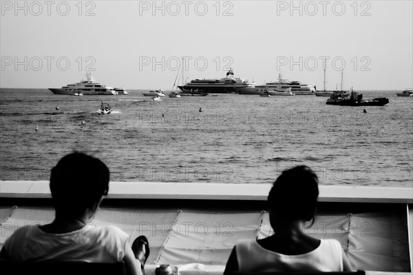 CoteAzur023 Cannes, la Croisette, les plages et la baie, yachts, deux femmes assises face à la baie