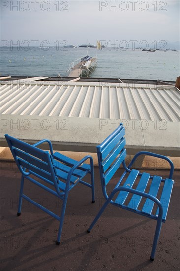 CoteAzur043 Cannes, la Croisette, chaises bleues, plage et yachts dans la baie