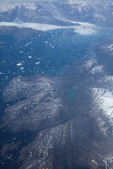 Groenland. Vue aérienne, côte sud-est près du Cap Farewell, terre du Roi Frédéric VI, (été 2008, 9000 m d'altitude) montagnes enneigées, glaciers, fjords, iles et icebergs