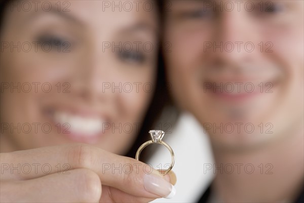 Closeup of ring and admiring couple.