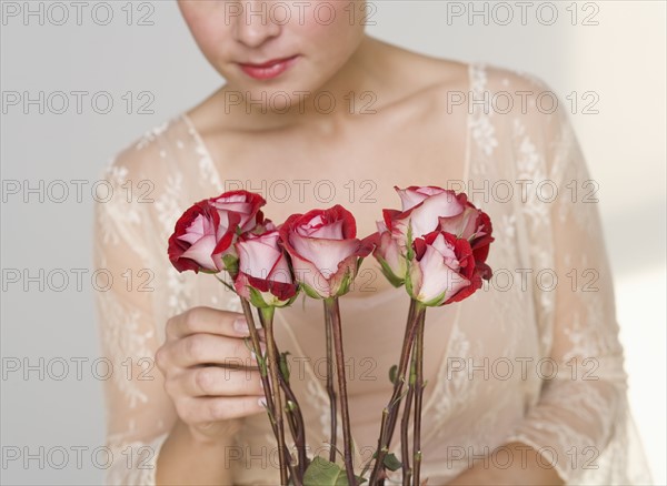 Close up of woman arranging stemmed roses.