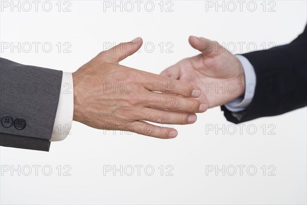 Businessmen about to shake hands.