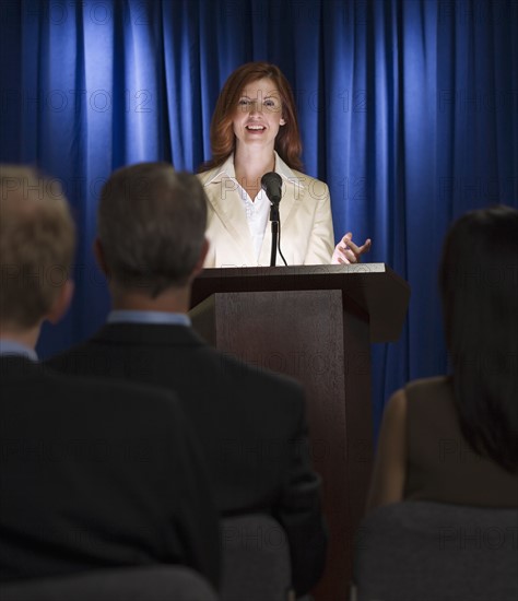 Businesswoman speaking at podium.