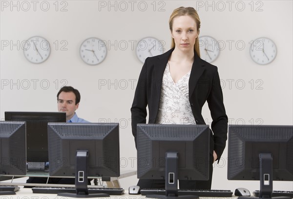 Businesswoman behind row of computers.