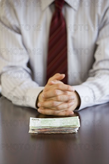 Businessman with stack of Euro banknotes.