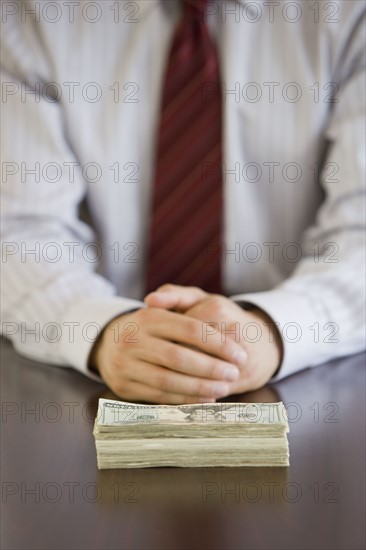 Businessman with stack of US Dollars.