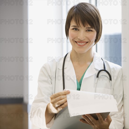 Female doctor holding chart.