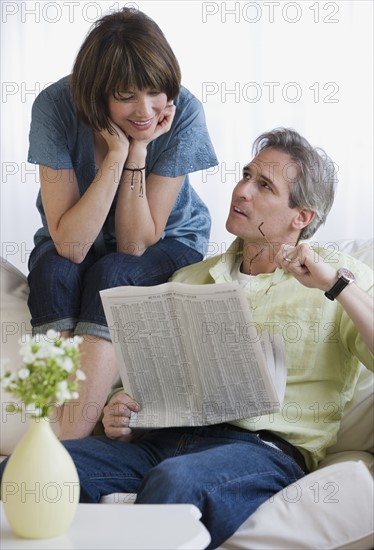 Couple looking at newspaper.