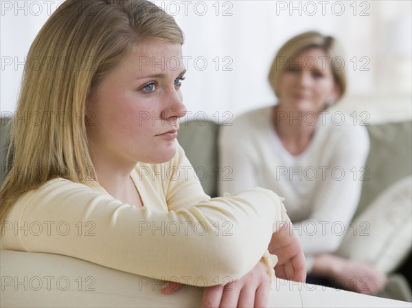Teenaged girl looking away from mother.