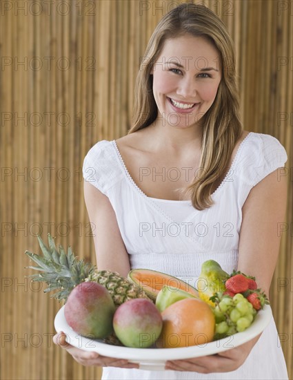 Woman holding bowl of fruit.