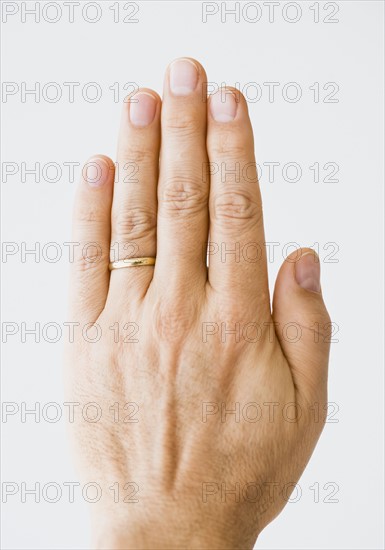 Close up of man’s hand wearing wedding ring.