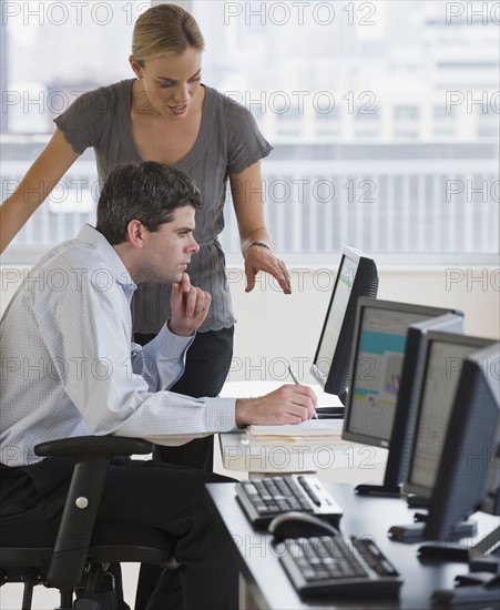 Businesspeople looking at computer.