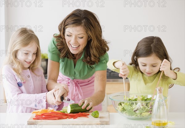Mother and daughters preparing food. Date : 2008