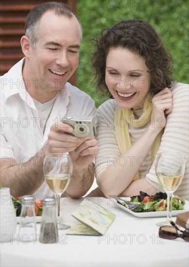 Couple looking at digital camera.