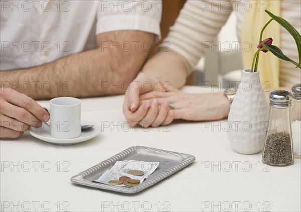 Money on restaurant table next to couple.