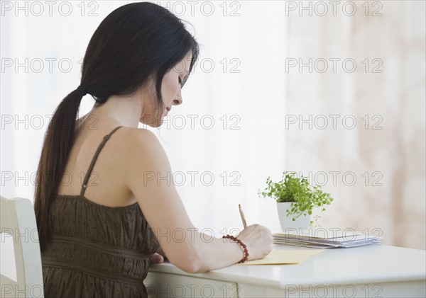 Woman writing at desk.