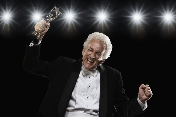 Man in tuxedo holding trophy. Date : 2008