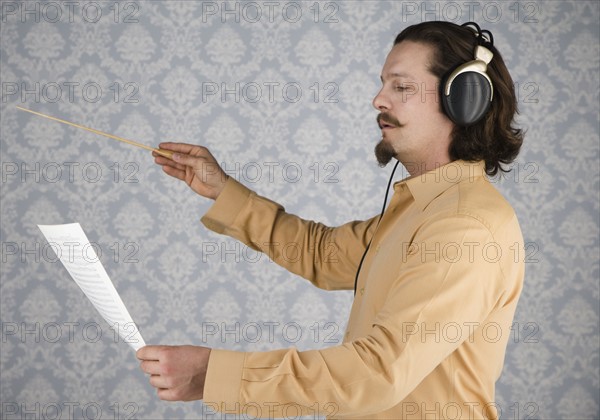 Man listening to headphones and conducting. Date : 2008