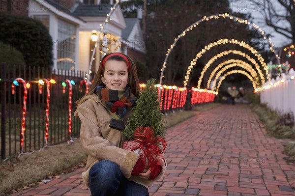 Girl holding potted plant. Date : 2008