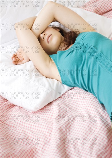 Exhausted teenage girl sleeping on bed. Date : 2008