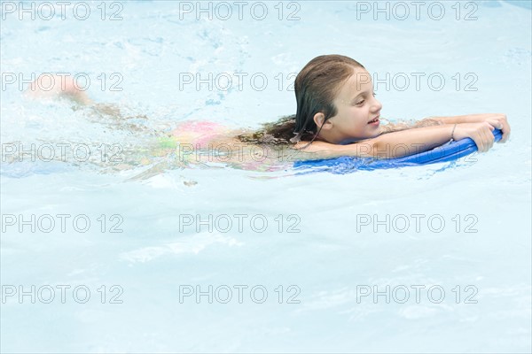 Girl using kickboard in swimming pool. Date : 2008