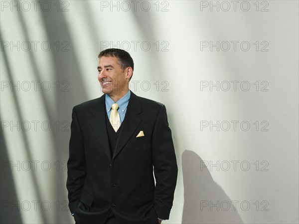 Businessman standing with hands in pockets. Date : 2008