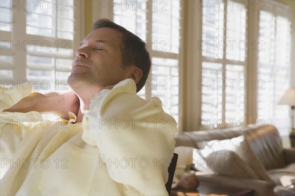 Man relaxing in livingroom. Date : 2008